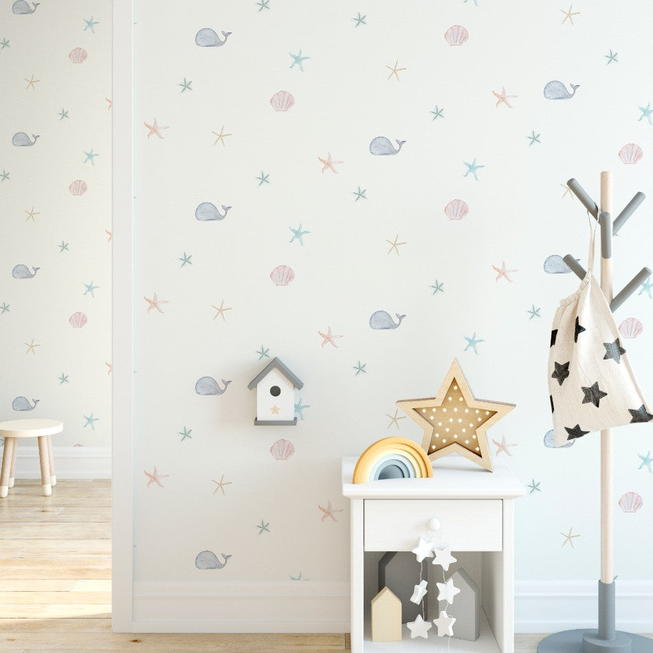 Descubre nuestro Papel Pintado Fondo Marino con dibujos marinos: ballena, conchas y estrella de mar para decorar la habitación infantil. Un diseño delicado y muy suave para una decoración náutica llena de encanto.