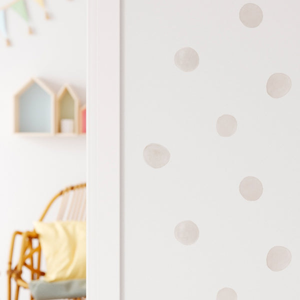 Papel pintado infantil Lunares beige: dulces círculos dibujados en acuarela, hechos con colores muy suaves de beige grisáceo para quien busca una decoración neutra para el cuarto infantil.