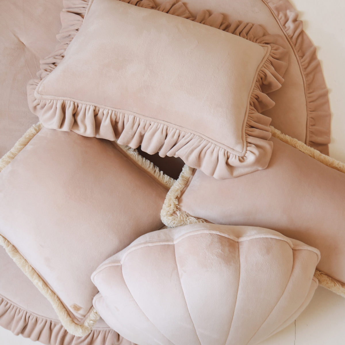 Decoración del cuarto de bebé romántica con cojín de volantes color rosa empolvado